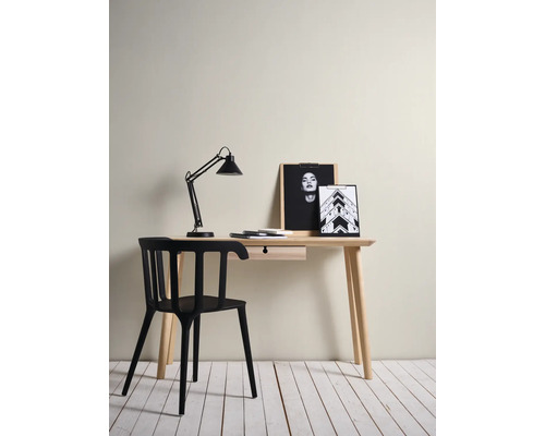 Minimalistischer Arbeitsplatz mit hellem Holzschreibtisch mit Schublade, modernem schwarzem Stuhl und schwarzer Schreibtischlampe.
