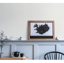 Wandbild Island Karte im Holzrahmen auf einer Wandleiste in einem minimalistisch eingerichteten Raum mit Teekanne und Stuhl.