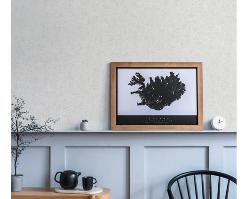 Ein gerahmtes Wandbild der Island-Karte auf einem Regal in einem minimalistischen Raum mit Wandpaneelen, einer Uhr und einer Teekanne.