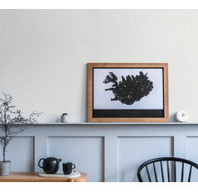 Gerahmtes Poster mit Island-Karte im Holzrahmen auf einem Regal in einem hellen, modern gestalteten Raum mit Wandpaneelen und Dekoration.