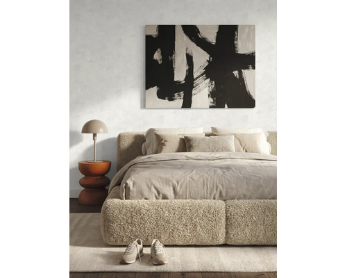 Modernes Schlafzimmer mit gepolstertem Bett, abstraktem Bild in Schwarz-Weiß und einem Beistelltisch mit Tischlampe.