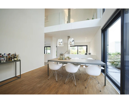 Modernes, helles Esszimmer mit großem Esstisch, sechs weißen Stühlen, silbernen Pendelleuchten, Holzparkett und großer Glasschiebetür.