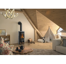 Moderner Kaminofen in einem hellen Dachgeschoss mit Holzverkleidung, Tipi-Zelt, Sofa und Geweih-Kronleuchter.