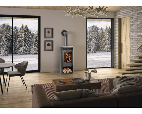 Moderner Kaminofen in einem hellen Wohnzimmer mit großen Fenstern und Blick auf eine verschneite Winterlandschaft.