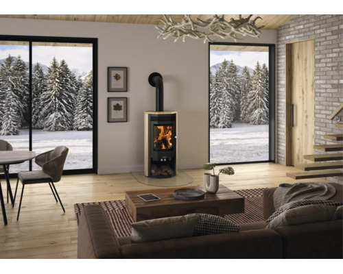 Moderner Kaminofen mit Steinverkleidung in einem hellen Wohnzimmer mit großen Panoramafenstern und Blick auf eine verschneite Winterlandschaft.