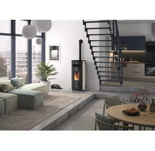 Moderner Pelletofen mit Glasscheibe und sichtbarem Feuer in einem hellen, minimalistischen Wohnzimmer mit Treppe und großen Fenstern.