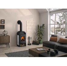 Heller, moderner Wohnraum mit schwarzem Kaminofen, großem Fenster, Sofa und Couchtisch aus Holz.