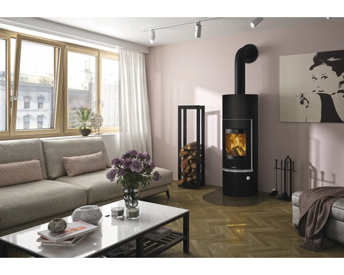 Moderner Kaminofen in Schwarz in einem hellen Wohnzimmer mit grauem Sofa, weißem Couchtisch und Kaminholzregal.