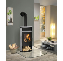 Justus Kaminofen mit Steinverkleidung und brennendem Holzfeuer in einem modern eingerichteten Wohnzimmer auf einer Glasbodenplatte.