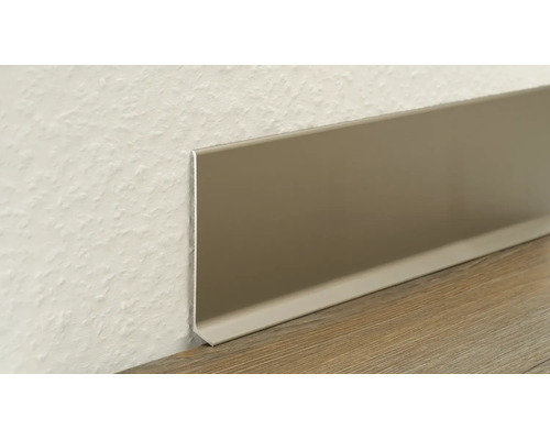Sockelleiste aus Aluminium an einer strukturierten Wand und einem Boden mit Holzdekor.