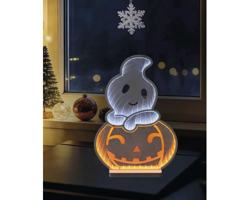 LED-Halloween-Dekoration mit Geist auf einem Kürbis und Unendlichkeitsspiegeleffekt, auf einem Tisch vor einem Fenster mit winterlicher Dekoration.