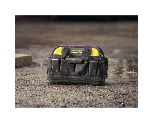 Stanley Fatmax Werkzeugtasche aus robustem Gewebe mit vielen Außentaschen und festem Boden auf unebenem Boden stehend.