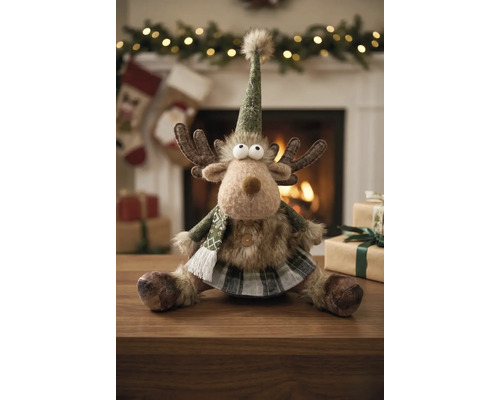Plüsch-Rentier mit spitzem Hut, Schal und kariertem Rock als Weihnachtsdekoration auf einem Holztisch vor einem hellen Kamin.