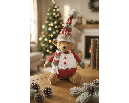 Weihnachts-Teddybär aus Plüsch mit Strickmütze und Schal, sitzend auf einem Holztisch in einem hellen, festlich dekorierten Raum.