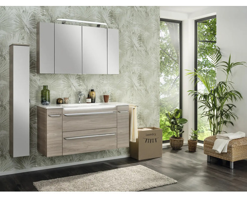 Modernes Badezimmerset mit Waschtisch in Holzoptik, weißem Waschbecken, großem Spiegelschrank und passendem Hochschrank vor Palmen-Tapete.