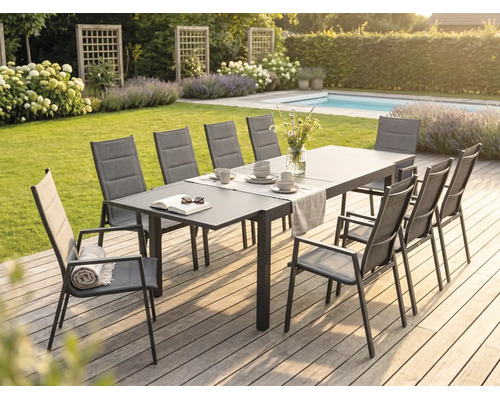 Moderne Garten-Essgruppe auf einer Holzterrasse mit großem Metalltisch und Hochlehner-Stühlen aus Textilgewebe in einer hellen Gartenanlage.
