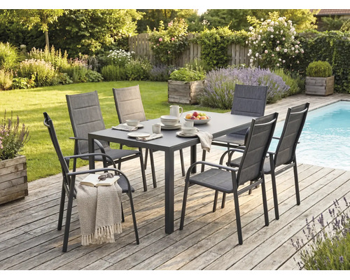 Moderne Garten-Essgruppe mit einem rechteckigen Tisch und sechs Sesseln auf einer Holzterrasse neben einem Pool im Garten.