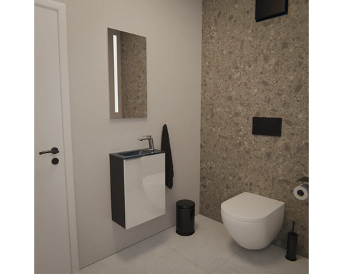 Modernes Gäste-WC mit wandhängendem Waschtisch, Spiegel mit Beleuchtung, Wand-WC und schwarzen Badaccessoires vor einer Wand in Terrazzo-Optik.