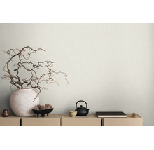 Hellbeige Tapete mit feiner Leinenstruktur hinter einem Sideboard mit dekorativen Zweigen in einer Vase und Teegeschirr im minimalistischen Stil.