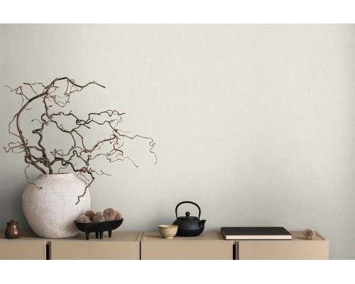 Hellbeige Tapete mit feiner Leinenstruktur hinter einem Sideboard mit dekorativen Zweigen in einer Vase und Teegeschirr im minimalistischen Stil.