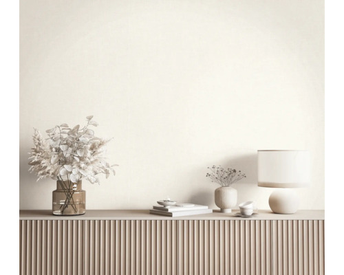 Modernes Sideboard mit geriffelter Front, dekoriert mit Glasvase mit Trockenblumen, Tischlampe und Keramikobjekten vor einer hellen Wand.