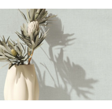 Strukturierte Tapete in Leinenoptik an einer Wand mit einer Vase mit Trockenblumen und Schattenwurf.