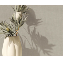 Vliestapete mit Leinenstruktur in Beige an einer Wand hinter einer Vase mit Protea-Blumen.