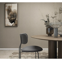 Strukturierte Tapete in einem modern gestalteten Esszimmer mit rundem Holztisch, modernem Stuhl und Wandbild.