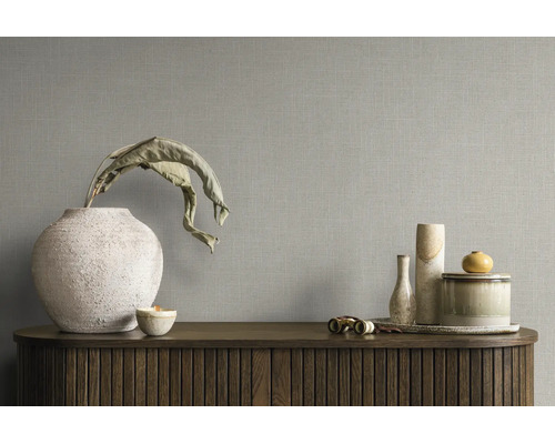 Tapete mit Leinenstruktur an einer Wand hinter einem Sideboard mit dekorativen Vasen und Schalen.