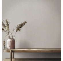 Tapete mit Leinenstruktur in einem hellen Raum mit Holzbank und Vase mit Trockenblumen.