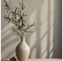Vliestapete mit Leinenstruktur an einer Wand hinter einer Vase mit Olivenzweig und Schattenwurf.