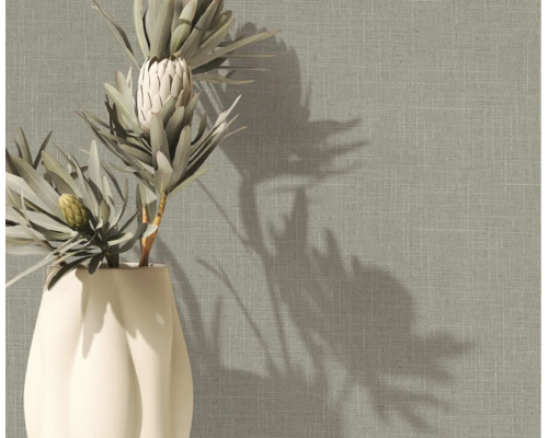 Strukturierte Tapete in Leinenoptik mit gewebter Stoffstruktur in einer Raumszene mit Vase und Trockenblumen.