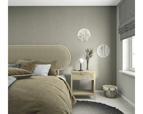Strukturierte Vliestapete in Graubeige in einem hellen Schlafzimmer mit Naturholzmöbeln, Wiener Geflecht-Kopfteil und sanfter Dekoration.