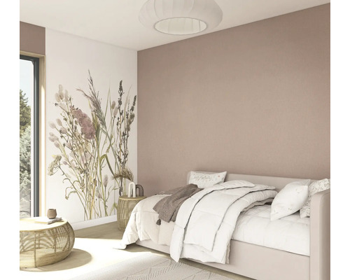 Helles Schlafzimmer mit weißem Bett, floraler Fototapete und altrosafarbener Wand, Beistelltischen aus Rattan sowie einer runden Plissee-Leuchte.