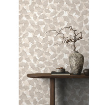 Tapete mit Ginkgo-Blattmuster in einem Wohnraum mit Holztisch und dekorativer Stein-Vase.