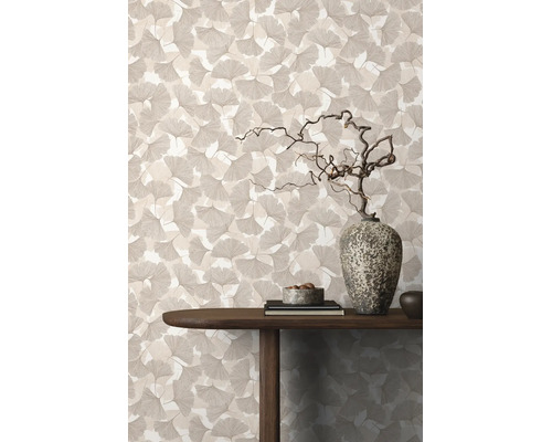 Tapete mit Ginkgo-Blattmuster in einem Wohnraum mit Holztisch und dekorativer Stein-Vase.