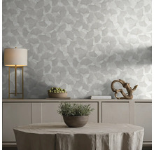Tapete mit Ginkgoblatt-Muster in einem hellen, organisierten Wohnraum mit Sideboard, Tischleuchte und dekorativen Elementen.