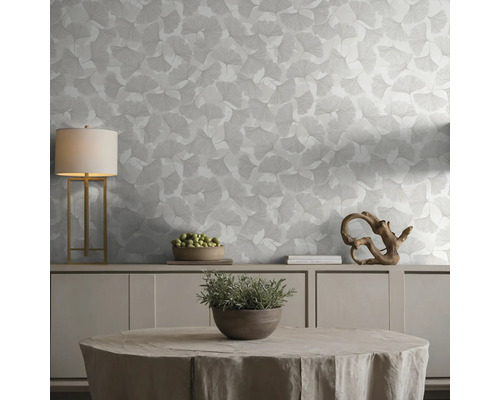 Tapete mit Ginkgoblatt-Muster in einem hellen, organisierten Wohnraum mit Sideboard, Tischleuchte und dekorativen Elementen.