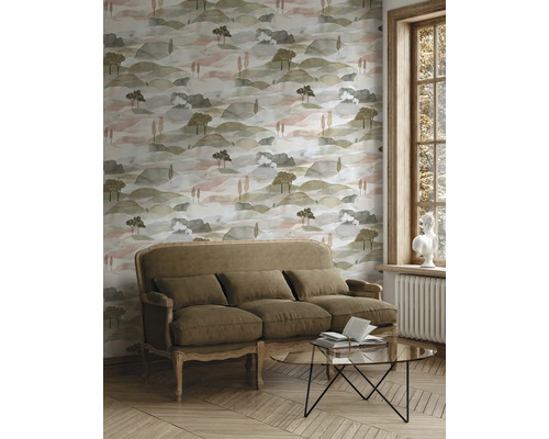 Vliestapete mit Landschaftsmuster in Aquarell-Optik in einem hellen Wohnzimmer mit klassischem Sofa, Glastisch und Fischgrätparkett.