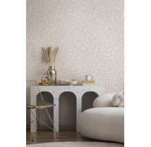 Helles Wohnzimmer mit Vliestapete im Blättermuster, Marmorkonsole mit Rundbögen, goldenem Metallstuhl und weißem Polstersofa.