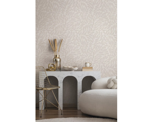 Helles Wohnzimmer mit Vliestapete im Blättermuster, Marmorkonsole mit Rundbögen, goldenem Metallstuhl und weißem Polstersofa.
