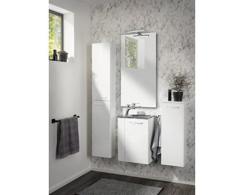 Badezimmermöbel-Set bestehend aus Hochschrank, Waschtisch mit Unterschrank, Spiegel mit Beleuchtung und Seitenschrank vor einer Marmorwand.
