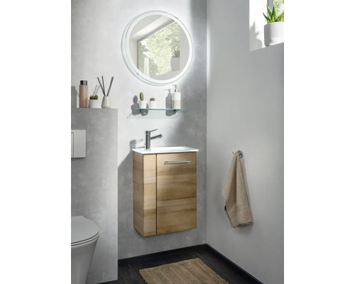 Modernes Gäste-WC mit wandhängendem Waschbeckenunterschrank in Holzoptik, weißem Waschtisch, Armatur und rundem LED-Spiegel.