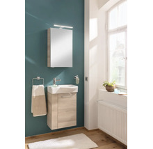 Modernes Gäste-WC mit hellem Waschtischunterschrank aus Holz, weißem Keramikwaschbecken, Spiegelschrank mit Beleuchtung und Handtuchhalter.