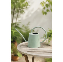 Moderne mintgrüne Metallgießkanne mit langem Ausguss und großem Rundgriff auf einem hölzernen Gartentisch.