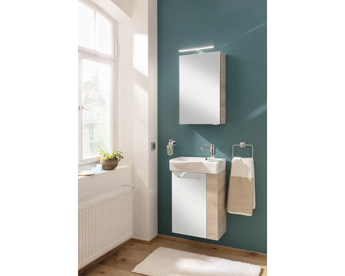 Modernes Badmöbel-Set mit weißem Unterschrank in Holzoptik, Keramikwaschbecken und Spiegelschrank mit Beleuchtung.