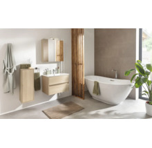 Helles Badezimmer mit Waschtischunterschrank in Holzoptik, passendem Spiegelschrank, Hochschrank, weißer Badewanne und Holzraumteiler.
