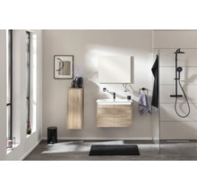 Modernes, helles Badezimmer mit Waschtischunterschrank und Hochschrank in Holzoptik sowie schwarzer Duscharmatur hinter Glaswand.