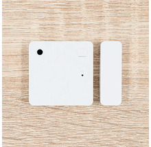 Tür- und Fenstersensor für Smart Home Systeme, bestehend aus einem quadratischen Sensor und einem schmalen Kontaktmagneten.