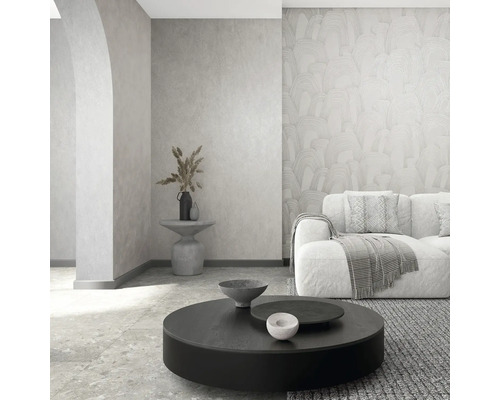 Modernes Wohnzimmer mit gemusterter Vliestapete, strukturierter Wand, Sofa und rundem Couchtisch in hellem, minimalistischem Design.